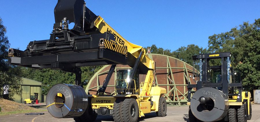 Coil boom spreader attachment for reach stacker.